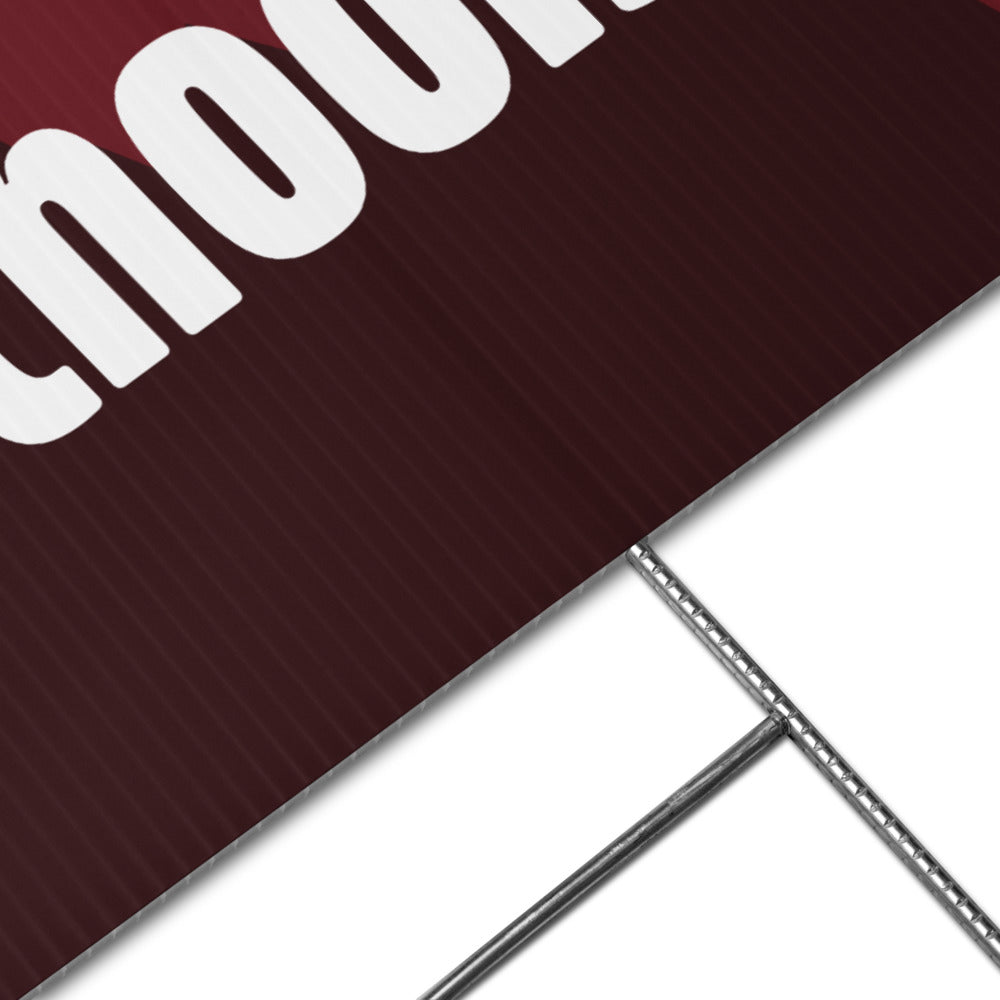 Close-up of a maroon sign with white text on a white background